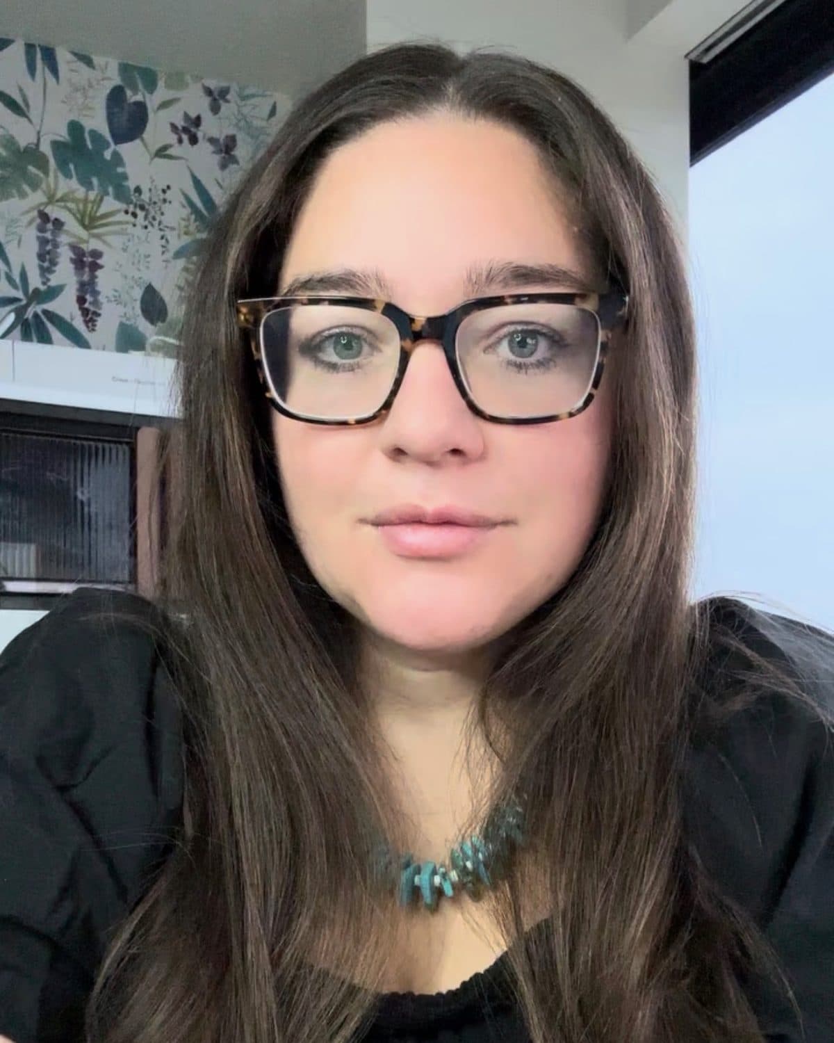 Amanda, the owner of Ehníta, in tortoiseshell glasses and a turquoise necklace