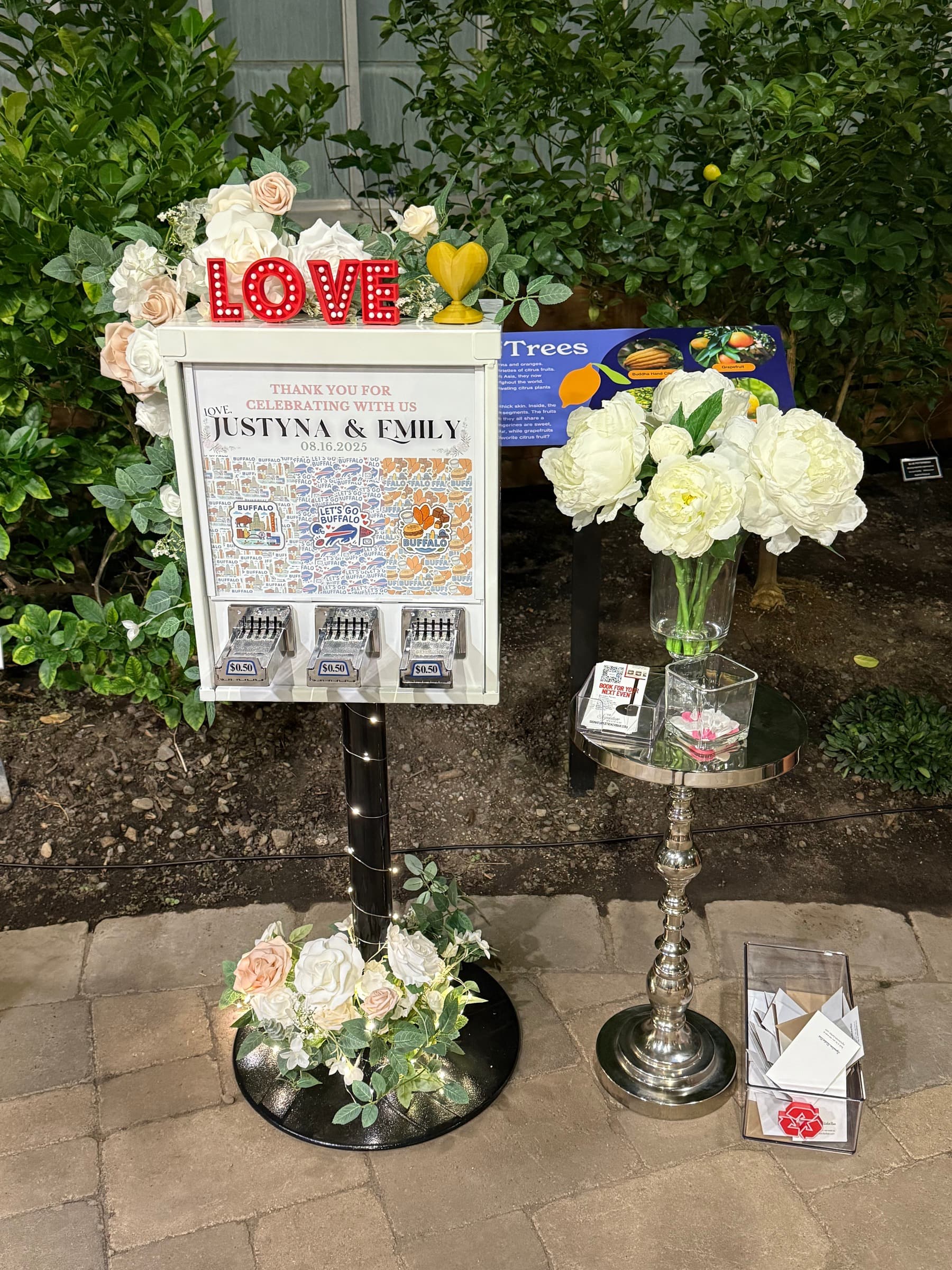 The sticker vending machine decorated with roses and a LOVE sign for a wedding